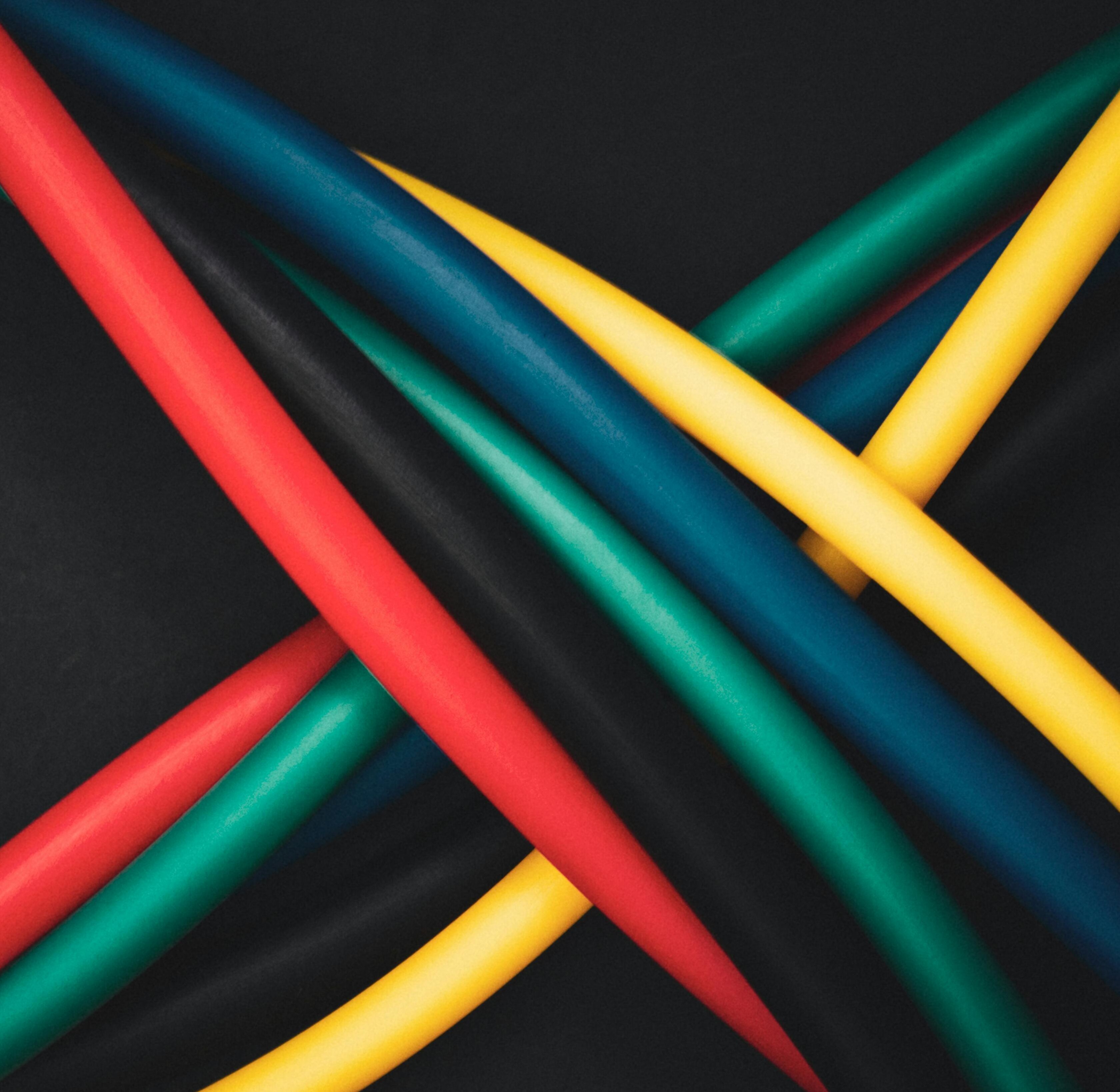 Multi-colored cables intertwined against a dark background, showing technology connections.